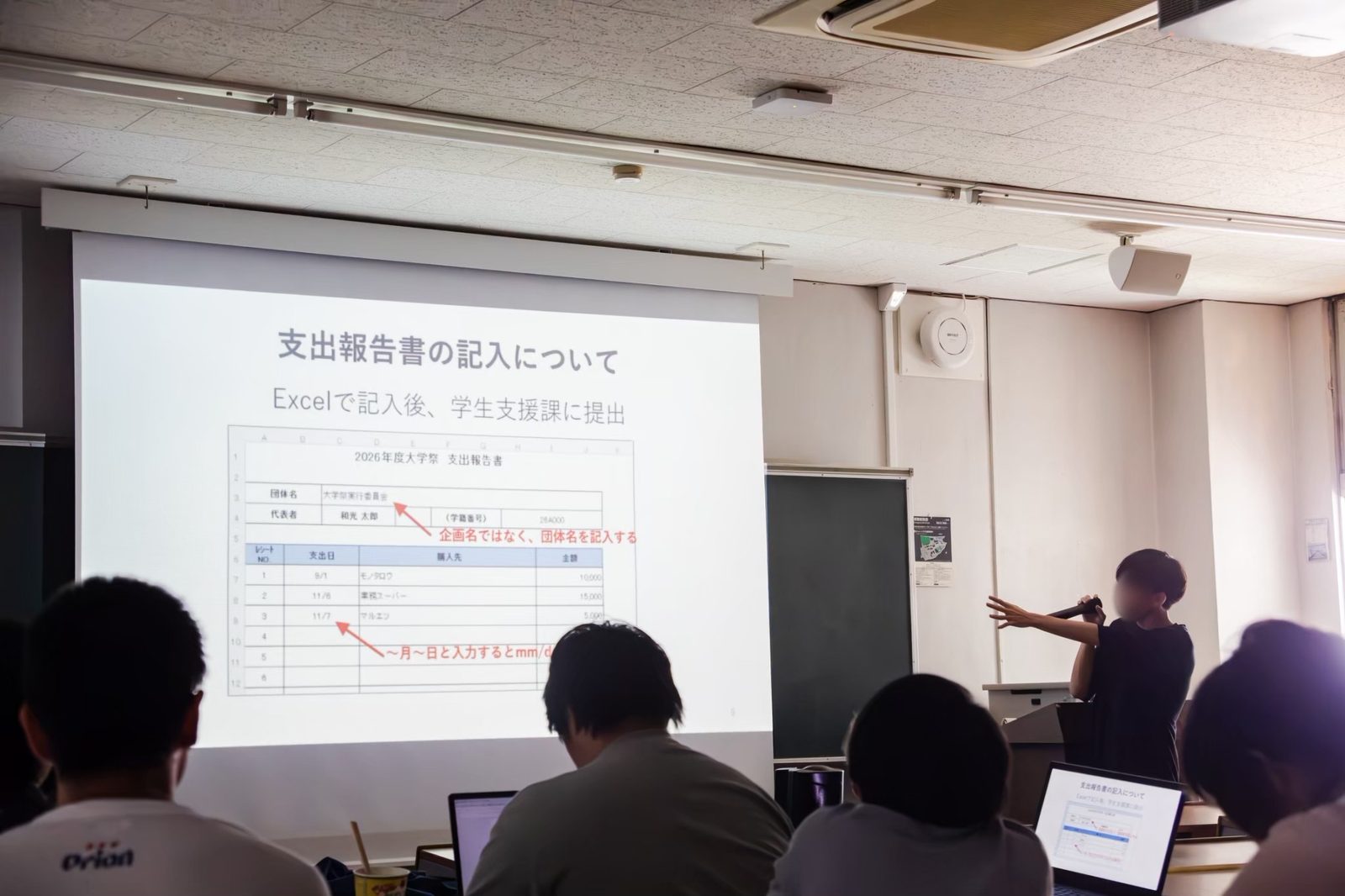「支出報告書の記入について」と映したスライドで、記入例を説明する実行委員