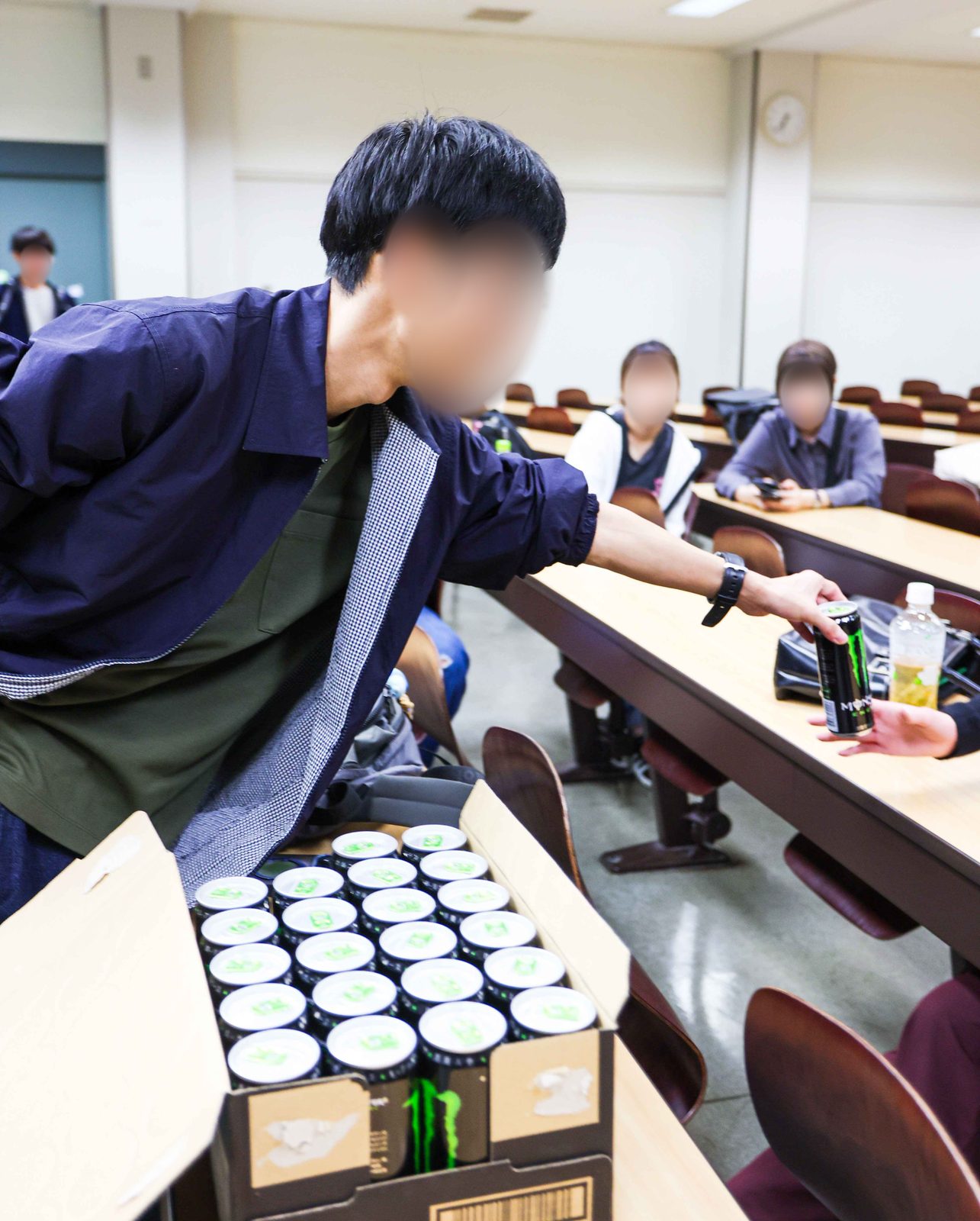 箱からモンスターエナジーを取り出して配る実行委員