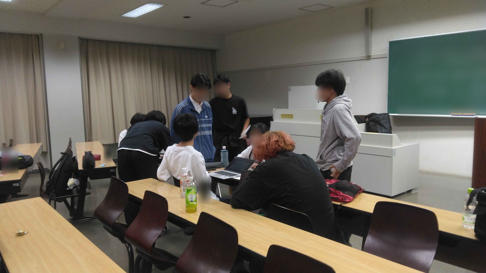 教室で、ノートパソコンのまわりに集まって相談する実行委員