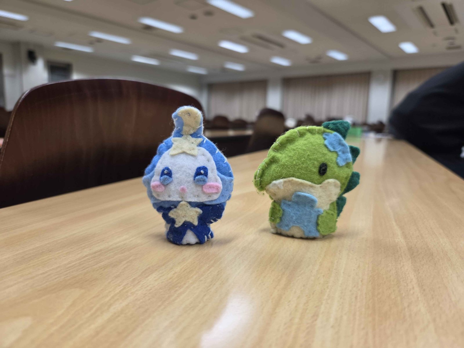 机の上に置かれた、フェルトで作ったつなぼしとザウルスの人形