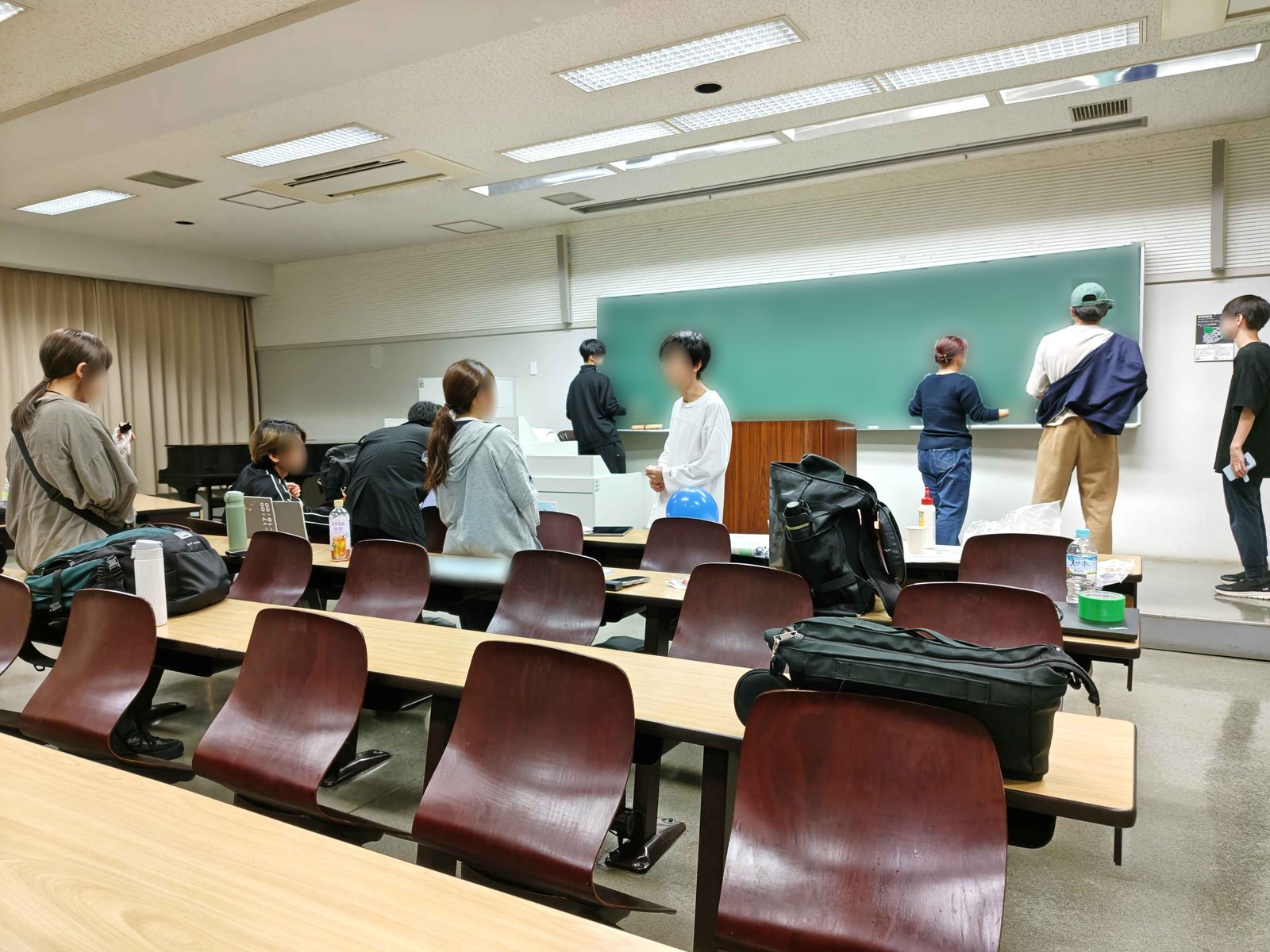 教室の黒板の前や机のまわりに集まって、作業や相談をする実行委員