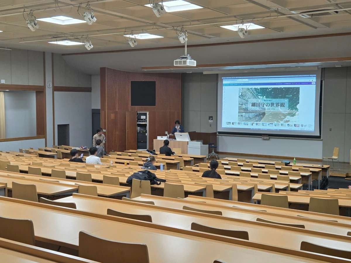 J401の後方から見た会場。スクリーンには講演会「細田守の世界観」のページが映り、座席に参加者が座っている