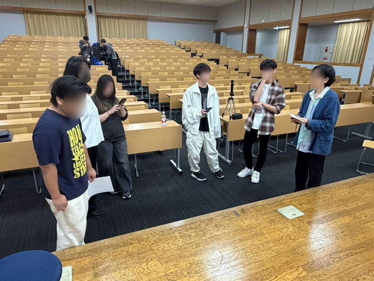 J401の前方で、台本を手に講演会の進め方を確かめる実行委員と畑中ゼミのスタッフ